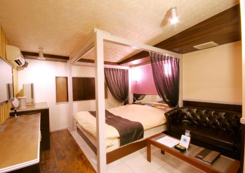 a bedroom with a bed and a couch in a room at GLAMROSE -Adult Only Motel- in Gotemba