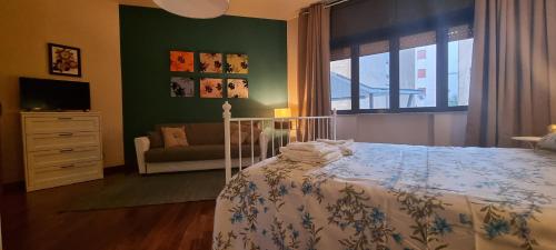 ein Schlafzimmer mit einem Bett, einem Sofa und einem Fenster in der Unterkunft Via Battisti 109 in Caserta