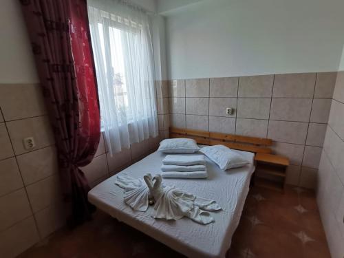 Habitación pequeña con cama y toallas. en Vila Cristal Costinesti en Costinesti