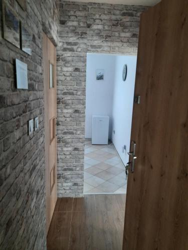 a hallway with a door and a brick wall at Raczkowska Apartament in Suwałki