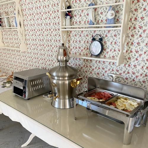 a kitchen counter with a table with food on it at Hotel Astam in Kostanay
