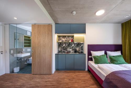 a bedroom with a bed and a bathroom with a sink at pradl elf my- apartment in Innsbruck