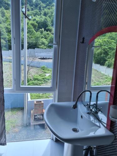 a bathroom with a sink in front of a window at Villa "Rezi-dencia" in Batumi