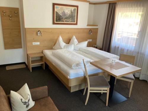 um quarto de hotel com uma cama grande e uma mesa em Garni Flurida em Selva di Val Gardena