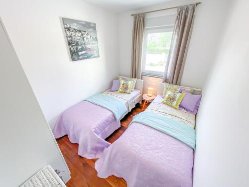 two twin beds in a room with a window at Apartment Josipa in Split
