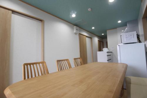 a kitchen with a table and chairs and a refrigerator at Yadokari Shima in Shima
