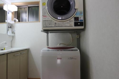 a microwave on top of a refrigerator in a kitchen at Yadokari Shima in Shima