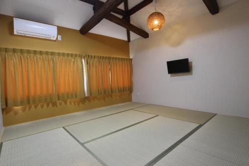 an empty room with a television and a window at Yadokari Shima in Shima