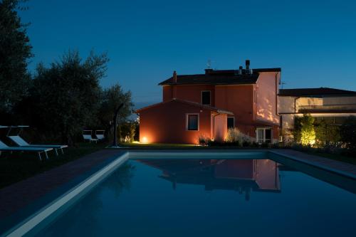 a villa with a swimming pool in front of a house at PODERE IL QUADRO in Lamporecchio