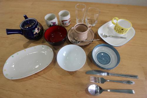 a table topped with white plates and cups and spoons at Yadokari Shima in Shima