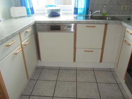 a kitchen with white cabinets and a sink at Ferienwohnungen Fuchshuber in Neukirchen vorm Wald