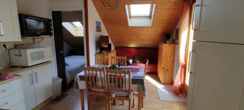 a kitchen with a table and chairs in a tiny house at Appartement T2 à BERNEX avec WiFi, vue sur montagne in Bernex