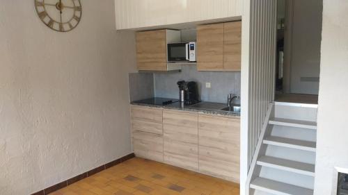a small kitchen with a sink and a clock on the wall at Bungalows du Lac de Rabais in Virton