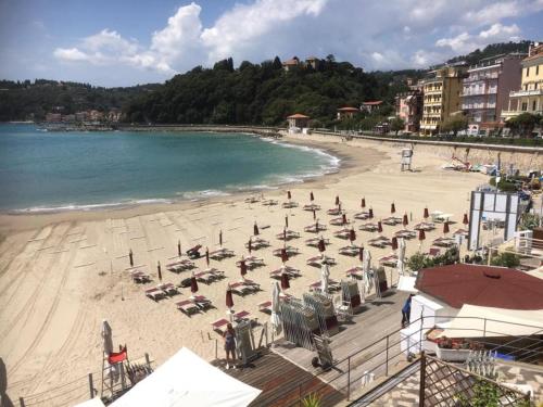 a beach with chairs and umbrellas and the ocean at Atena in La Spezia