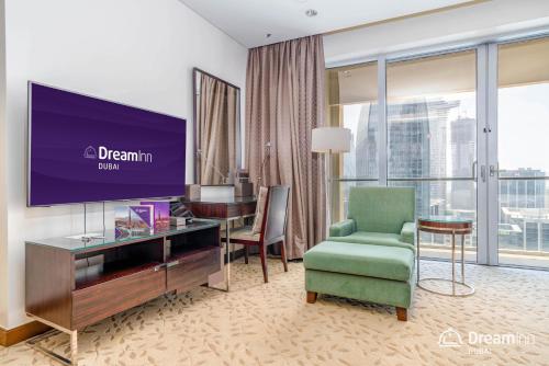 a hotel room with a tv and a chair and a desk at Dream Inn Apartments - Premium Apartments Connected to Dubai Mall in Dubai