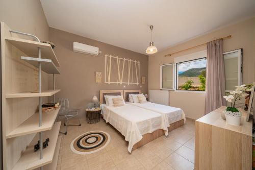 a bedroom with a bed and a large window at Cicada Home in Karavadhos