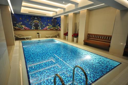 a swimming pool in a building with a painting on the wall at Neorion Hotel - Special Class in Istanbul