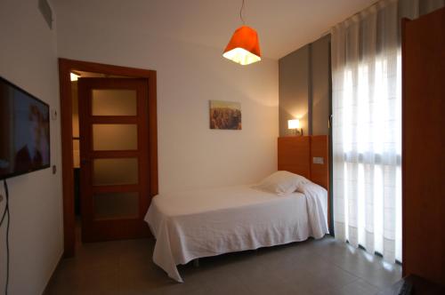 a bedroom with a white bed and a window at Resort Sitges Apartment in Sitges