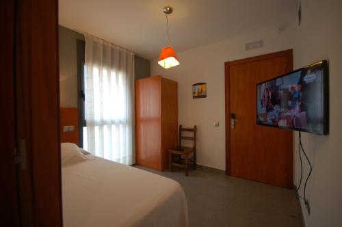 a bedroom with a bed and a flat screen tv at Sitges Apartment in Sitges