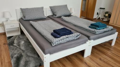 2 Betten in einem Zimmer mit blauen Kissen darauf in der Unterkunft Ferienwohnung-Kormann in Schkopau