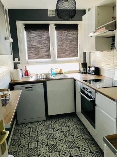 a kitchen with a sink and a stove at Le Foch in Ouistreham