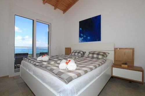En eller flere senge i et værelse på Sunset Sea View Villa 3