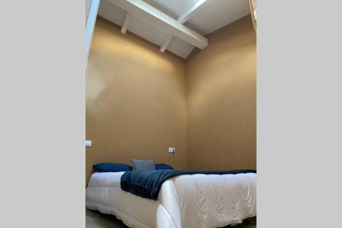 Schlafzimmer mit einem Bett mit weißer Bettwäsche und blauen Kissen in der Unterkunft Casa Curias, para 7 personas en Molinillo in Molinillo