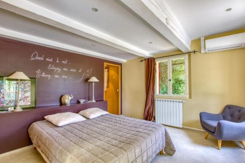une chambre avec un lit et un tableau noir au mur dans l'établissement Le Mas de la Noria, à La Cadière-dʼAzur
