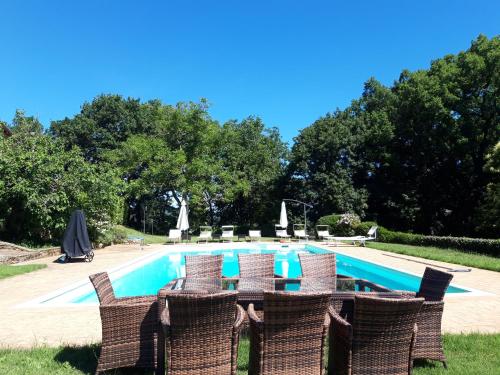 a swimming pool with wicker chairs and a table and a swimming pool at Castellare in Chiusdino