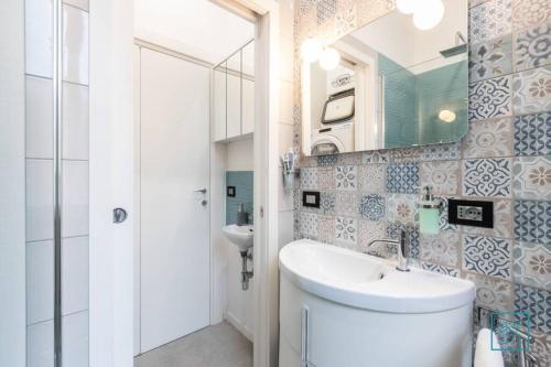 y baño con lavabo, aseo y espejo. en Appartamento incantevole Lido di Ostia- Corallo Azzurro, en Lido di Ostia