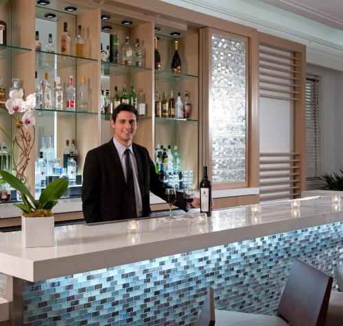 a man standing in front of a counter in a restaurant at Marseilles Beachfront Hotel in Miami Beach