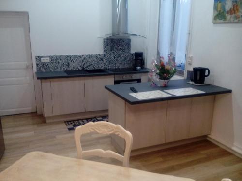 une cuisine avec une table et une chaise dans une pièce dans l'établissement La Dauversière 1, à La Flèche