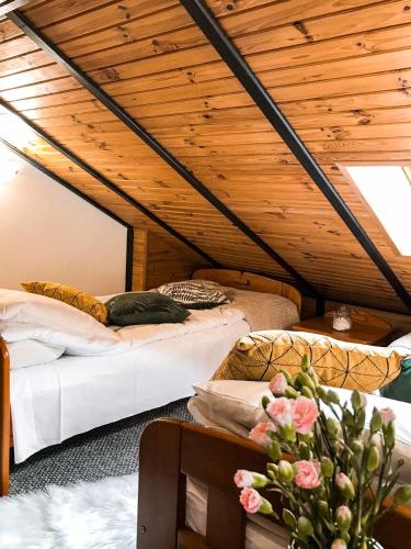 two beds in a room with wooden ceilings at Willa Pod Skocznią in Karpacz