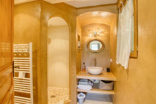 une salle de bain avec un lavabo et un miroir dans l'établissement Le Mas de la Noria, à La Cadière-dʼAzur