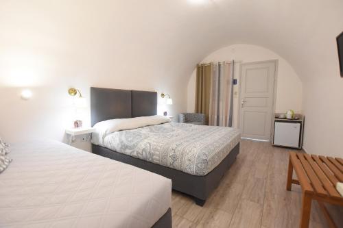 a bedroom with two beds and a table at Rodakas Hotel in Akrotiri