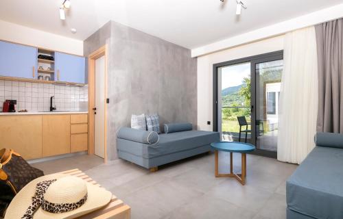 a living room with a blue couch and a table at Marajo Suites in Skala Potamias