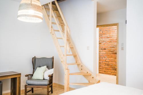 Cette chambre dispose d'un escalier en bois et d'une chaise. dans l'établissement Istebna 401 MURY, à Istebna