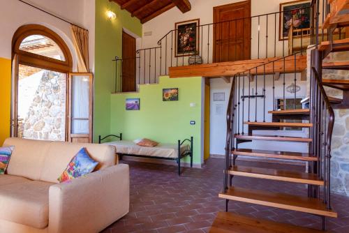 a living room with a spiral staircase and a couch at Locanda Vesuna Hotel Countryhouse in Pienza