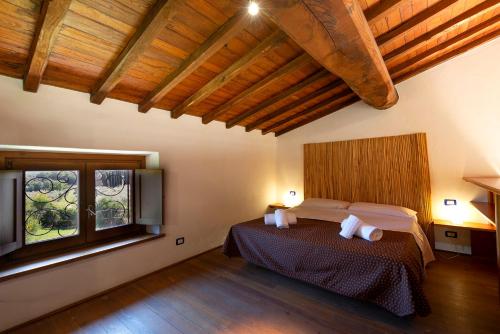 a bedroom with a bed and a large window at Locanda Vesuna Hotel Countryhouse in Pienza