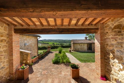 an external view of a stone house with a brick wall at Locanda Vesuna Hotel Countryhouse in Pienza