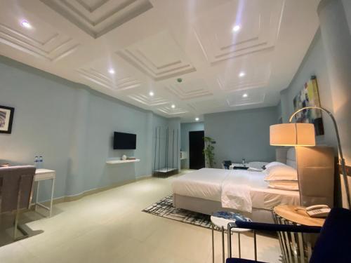 MUSE Boutique Hotel في إينوجو: غرفة نوم كبيرة مع سرير ومكتب
