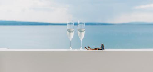 two wine glasses sitting on top of a table at Hotel Miramare in Crikvenica