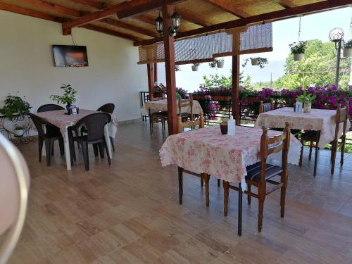a dining room with tables and chairs and flowers at Shoposki Guest House in Ohrid