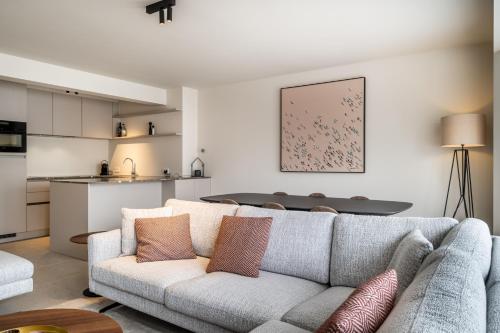 uma sala de estar com um sofá e uma cozinha em - Maja - Peaceful luxurious appt near the beach in Koksijde em Koksijde