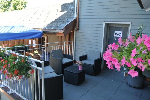 a patio with chairs and flowers on a house at Gasthaus Gemsli in Nesslau
