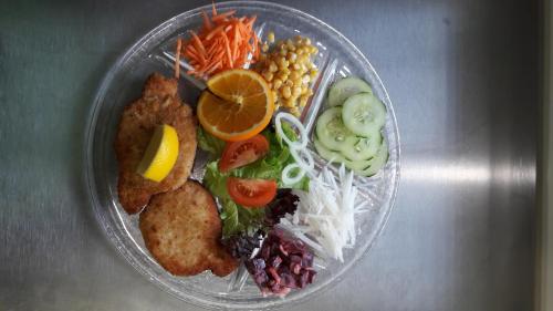 uma tigela de plástico de alimentos com vegetais e outros alimentos em Gasthaus Gemsli em Nesslau