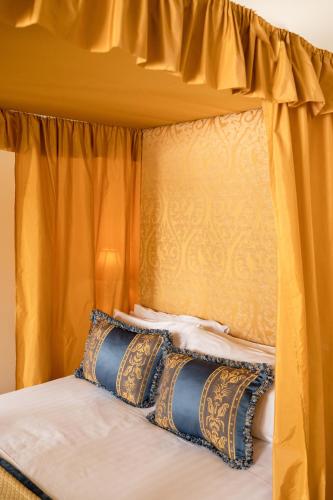 a bed with an orange canopy with pillows on it at Springkell in Eaglesfield