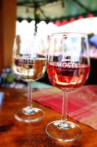 two glasses of wine sitting on top of a table at Johannishof Wein-Café & Gästehaus in Mesenich