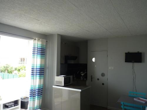 un salon avec un four micro-ondes et une fenêtre dans l'établissement Charmant Studio, Les Goélettes, Narbonne Plage, à Narbonne-Plage