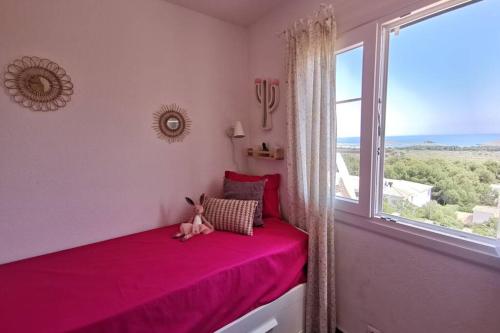 a bedroom with a pink bed and a large window at V. Lona: beautiful duplex with a stunning seaview in Es Mercadal